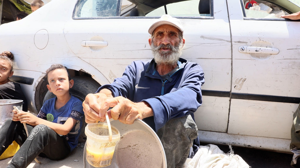 بعد كفاحٍ، تمكن زياد الغريز - وهو نازح في غزة - من الحصول على كوب من حساء العدس من أحد المطابخ المجتمعية الخيرية.